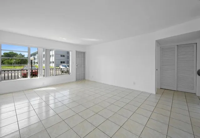 a view of an empty room and kitchen