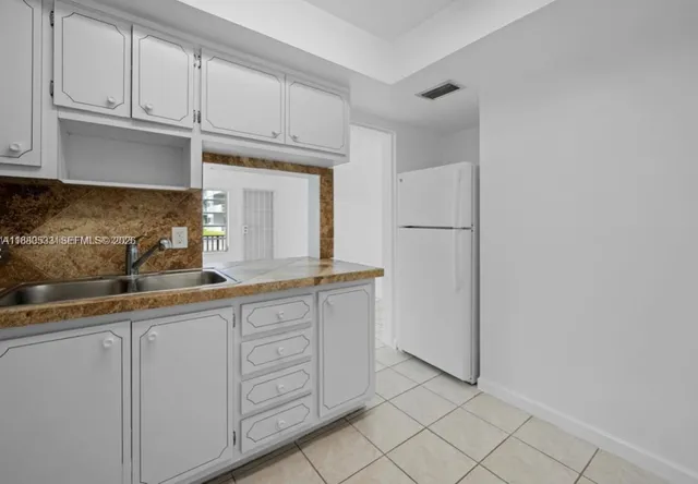 a kitchen with white cabinets and white appliances