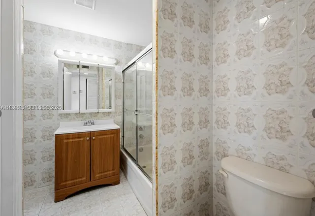 a bathroom with a granite countertop sink a toilet and a bathtub