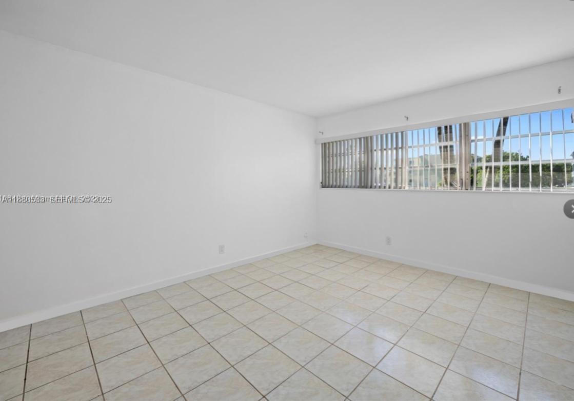 1400 Northeast 169th Street, Unit 115 Miami, FL 33162 - Photo 7 of 17 a view of an empty room with a window