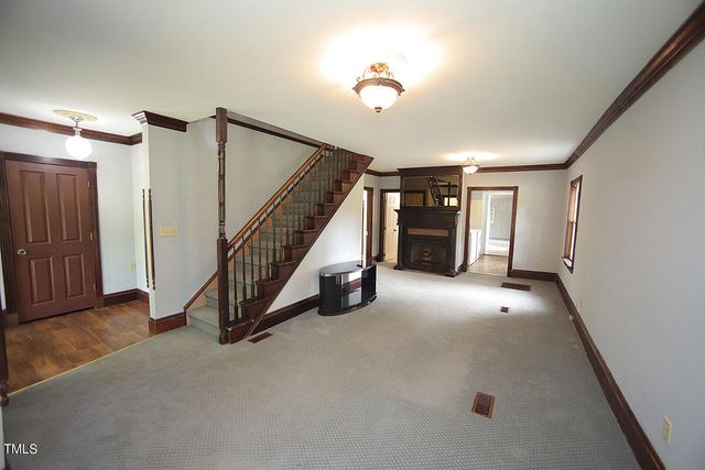 a view of an empty room with stairs and a window