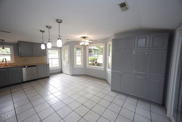 a view of a kitchen with a sink and an empty room