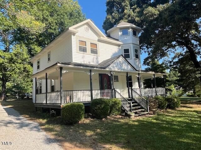 a view of a white house with a yard and plants