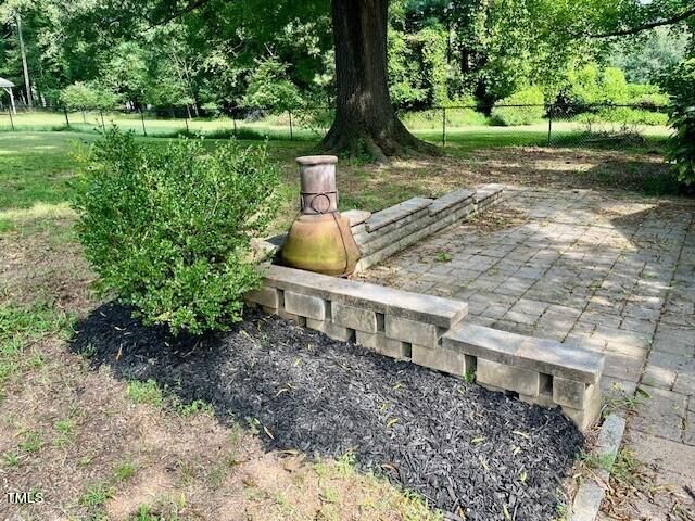 a view of a yard with plants and a bench