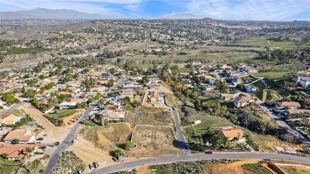 an aerial view of residential houses with outdoor space and trees