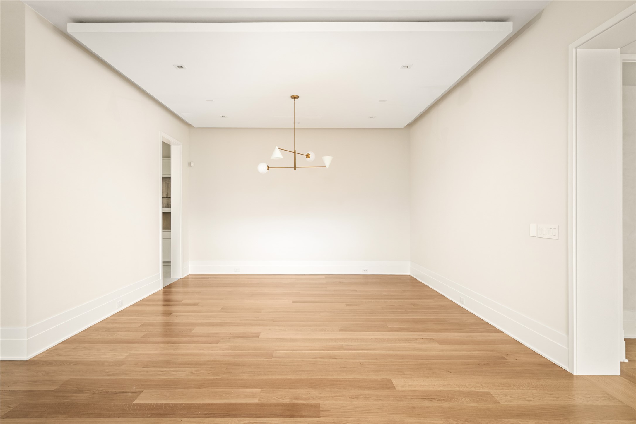 4006 Overbrook Lane Houston, TX 77027 - Photo 7 of 50 A refined dining space defined by clean lines, a tray ceiling with subtle cove lighting, and a sculptural designer fixture - offering a neutral canvas ready to be personalized