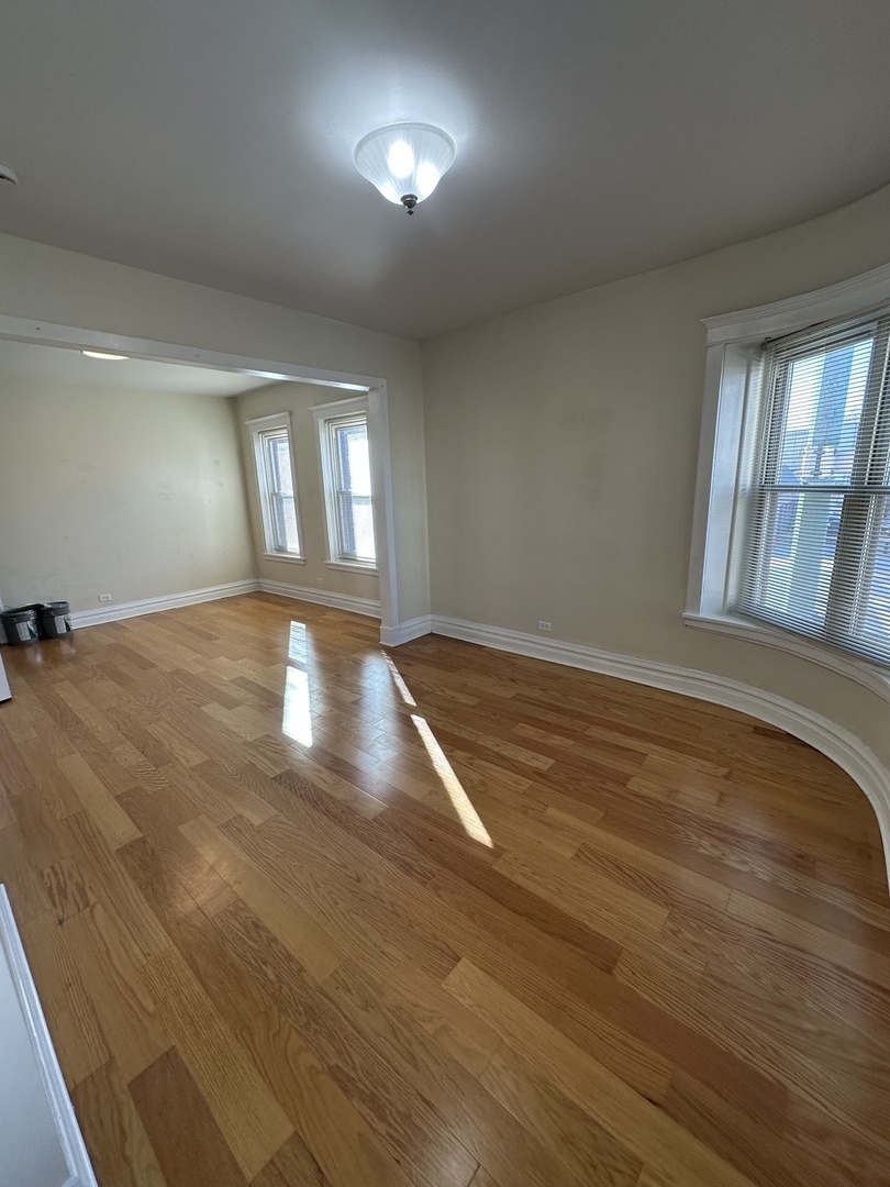 953 North California Avenue, Unit 2F Chicago, IL 60622 - Photo 12 of 16 an empty room with wooden floor and windows