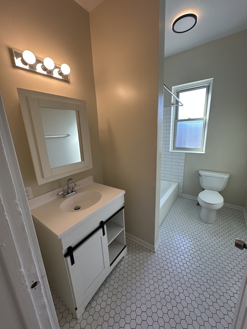953 North California Avenue, Unit 2F Chicago, IL 60622 - Photo 6 of 16 a bathroom with a sink a toilet and mirror