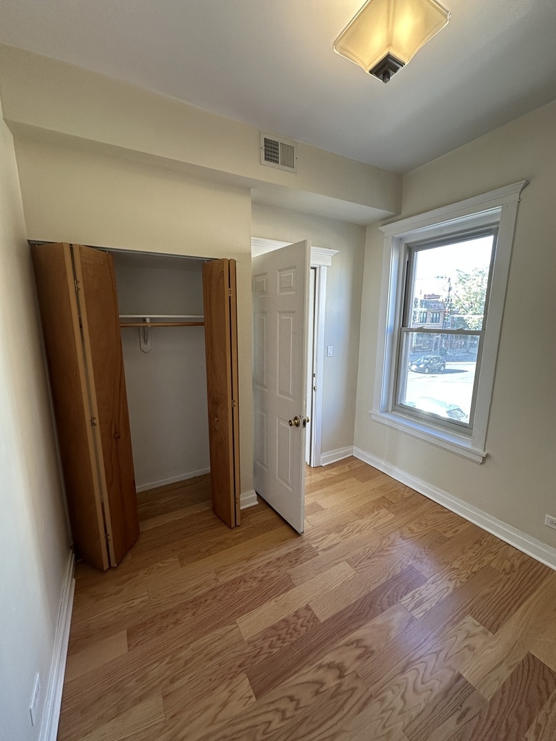 953 North California Avenue, Unit 2F Chicago, IL 60622 - Photo 7 of 16 wooden floor in an empty room with a window