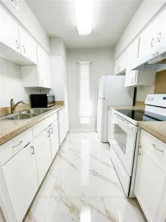 a kitchen with white cabinets and white appliances