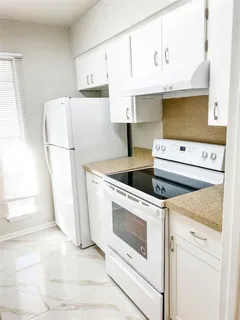 a kitchen with white cabinets and white appliances