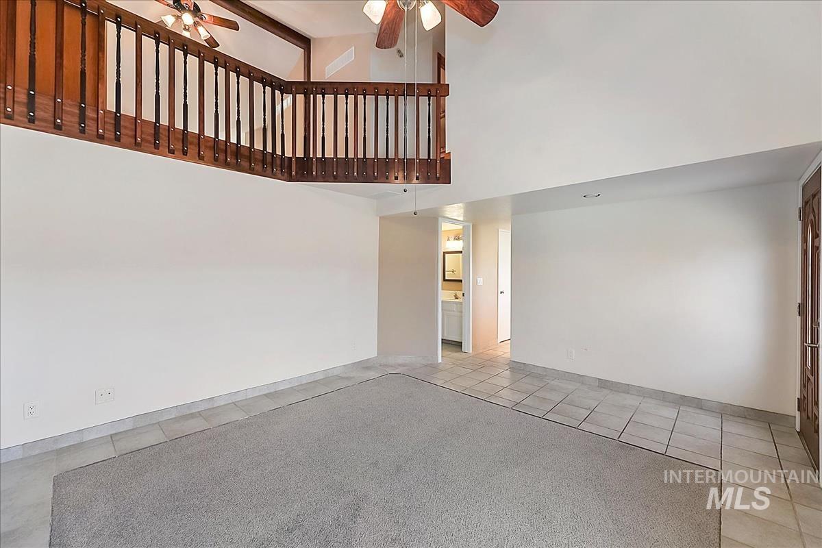 2804 West Sunrise Rim Road Boise, ID 83705 - Photo 7 of 50 Volume ceiling in a living area featuring a carpeted section and tile flooring