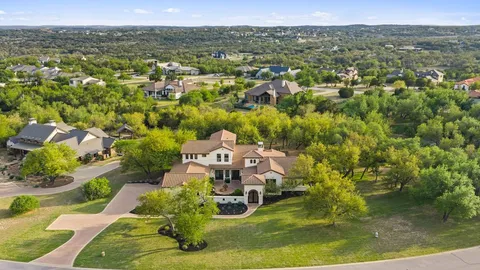 an aerial view of residential houses with outdoor space and trees