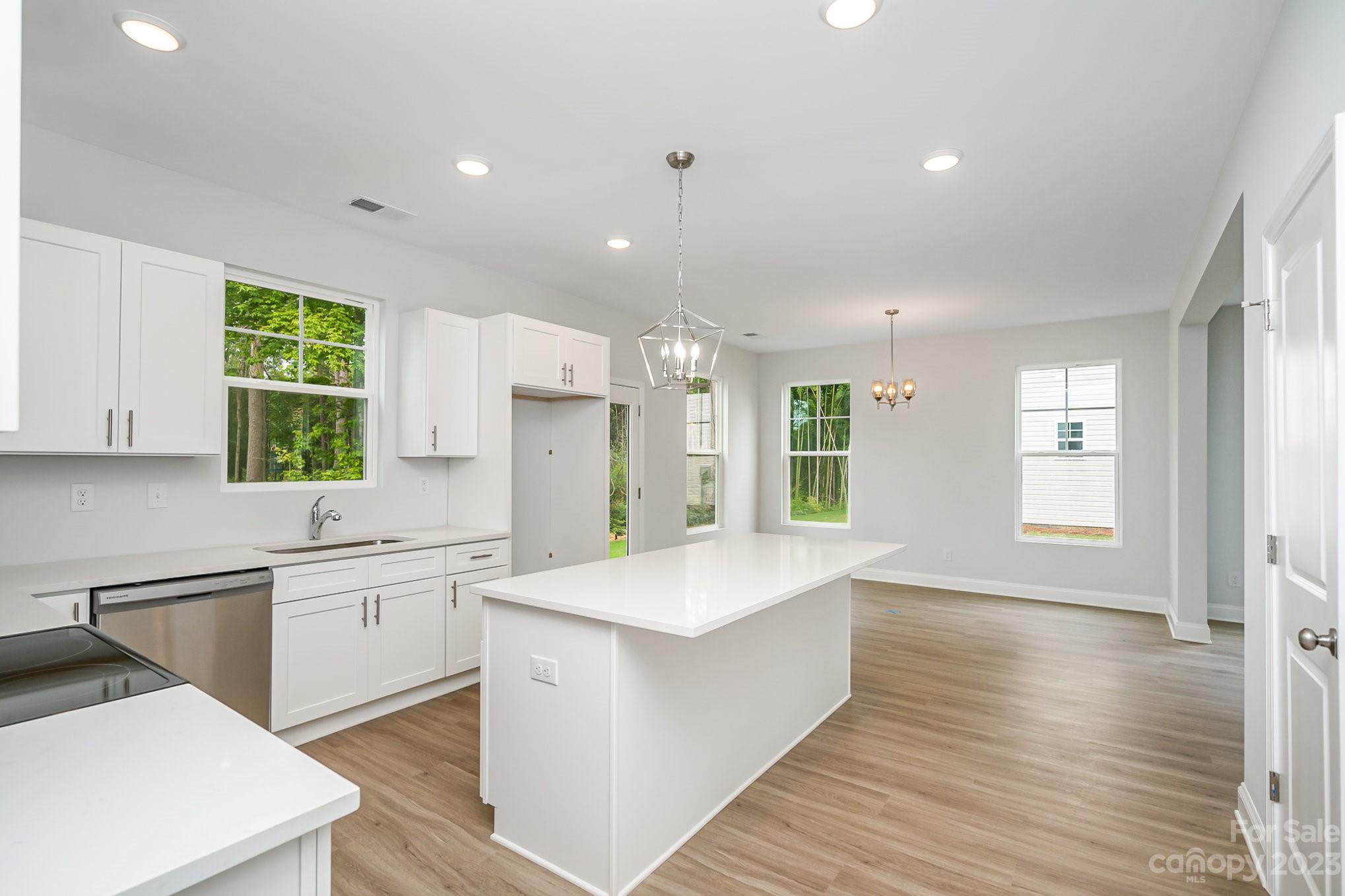 1016 Helms Road Charlotte, NC 28214 - Photo 12 of 39 a large kitchen with stainless steel appliances kitchen island a large counter top and a wooden floors