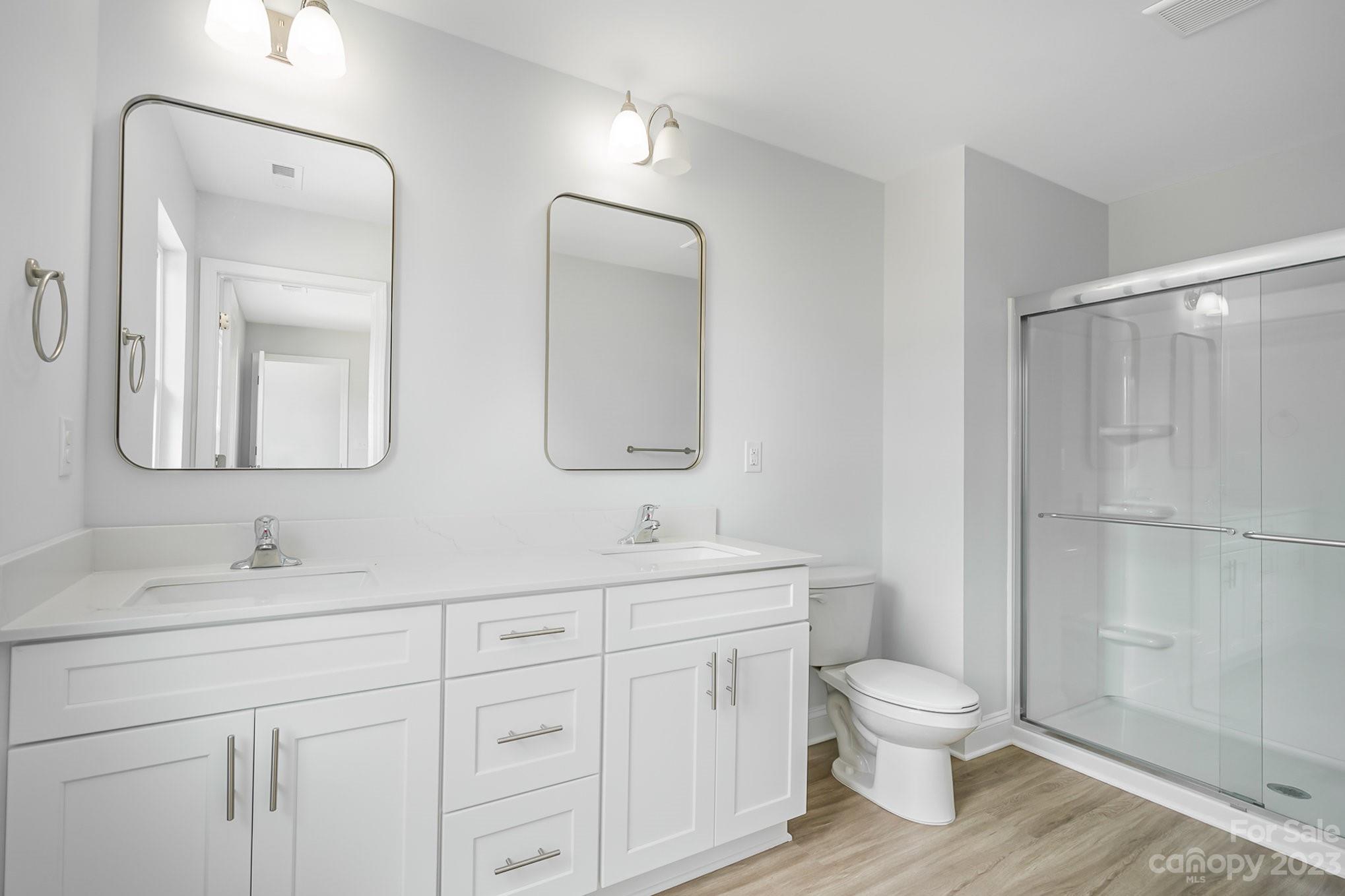 1016 Helms Road Charlotte, NC 28214 - Photo 24 of 39 a bathroom with a toilet sink double vanity and mirror
