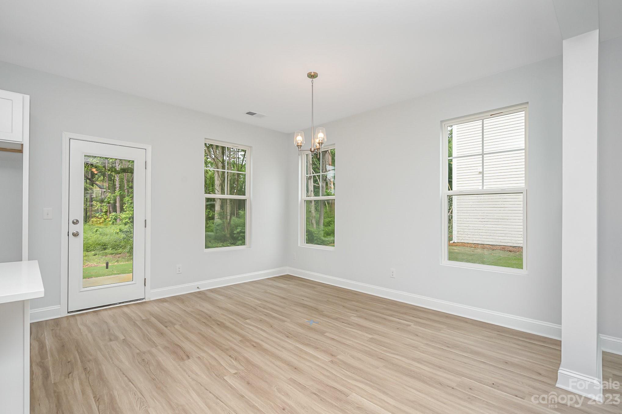1016 Helms Road Charlotte, NC 28214 - Photo 6 of 39 a view of an empty room with wooden floor and a window
