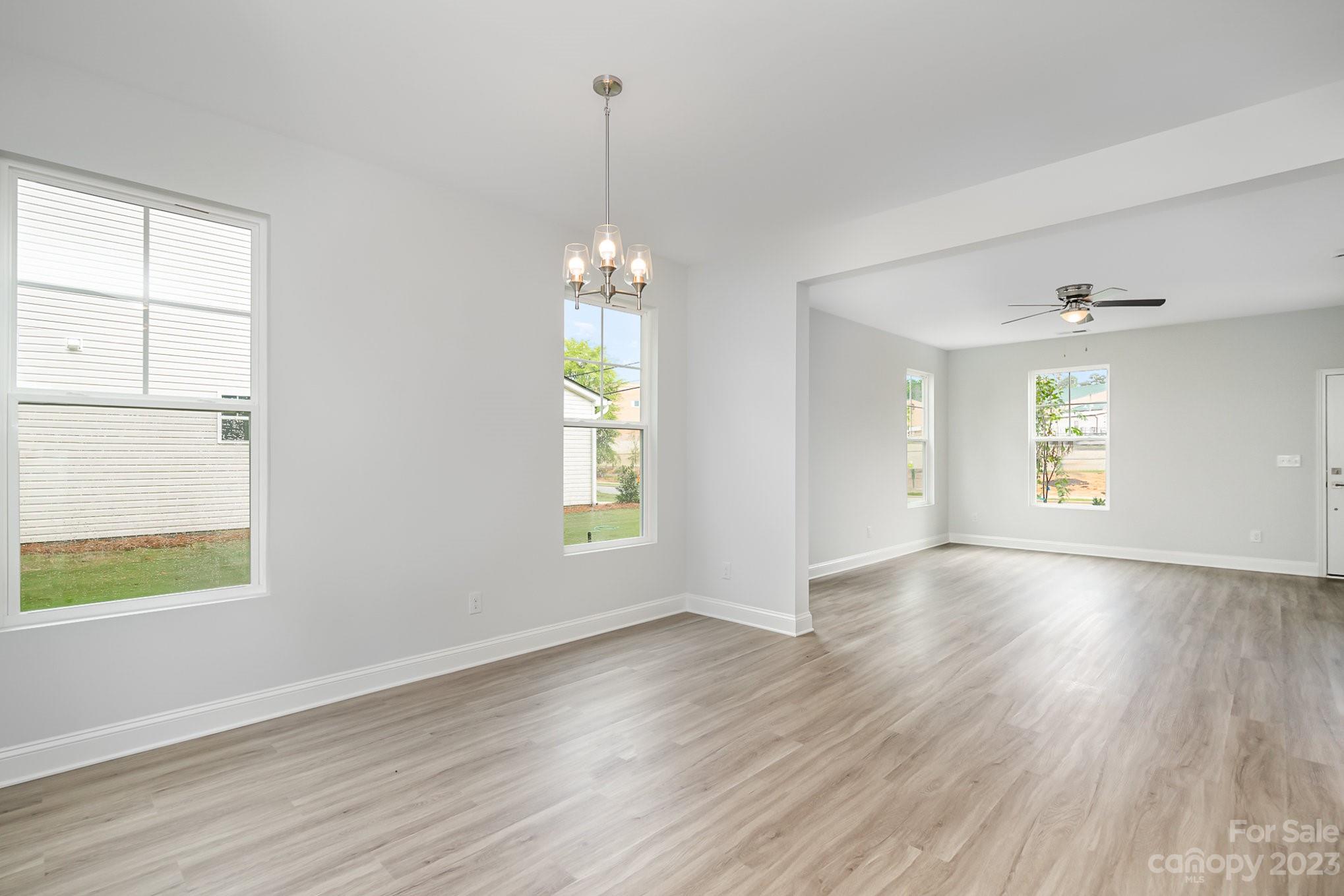 1016 Helms Road Charlotte, NC 28214 - Photo 7 of 39 an empty room with wooden floor chandelier and windows