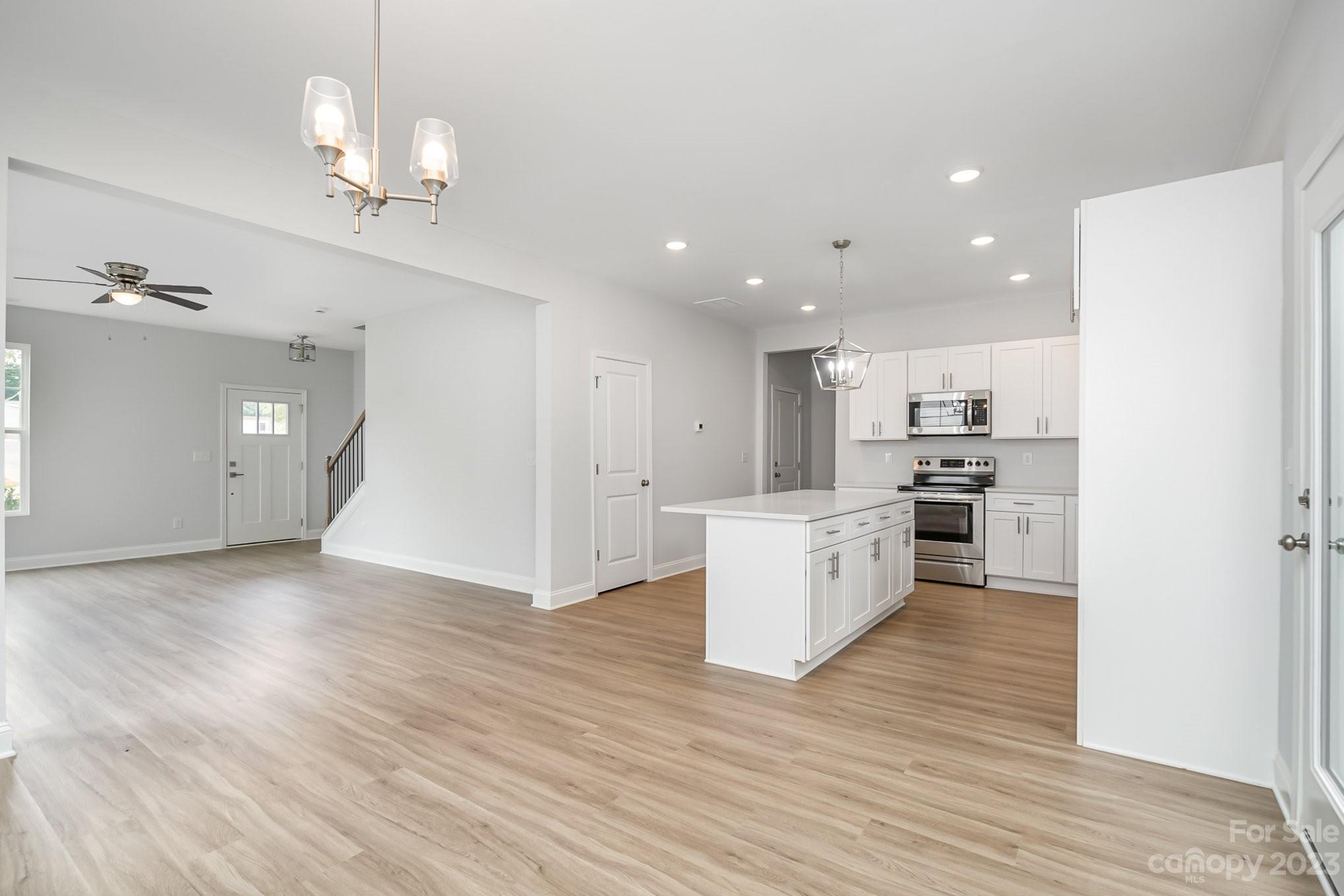 1016 Helms Road Charlotte, NC 28214 - Photo 8 of 39 a kitchen with stainless steel appliances kitchen island wooden floors cabinets and center island