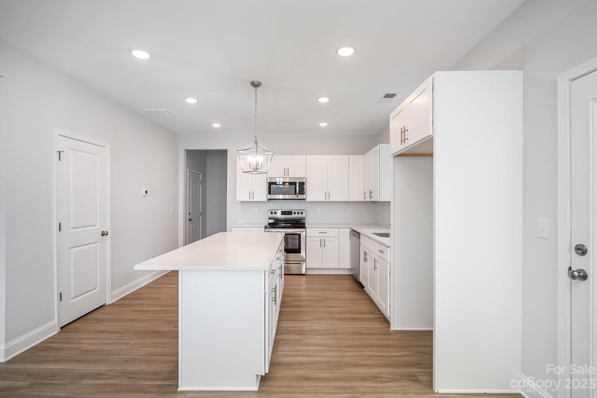1016 Helms Road Charlotte, NC 28214 - Photo 10 of 39 a large kitchen with kitchen island a sink a stove and a refrigerator