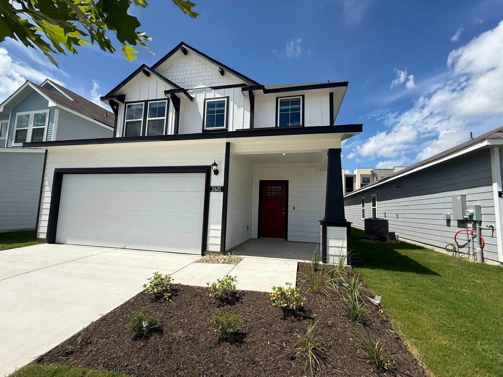 2601 Totley Road Pflugerville, TX 78660 - Photo 2 of 40 View of front of property featuring board and batten siding, an attached garage, a front yard, concrete driveway, and covered porch