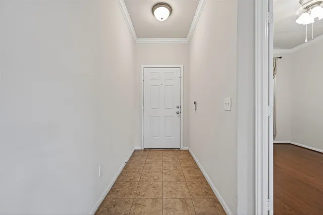 a view of an empty room with wooden floor and a ceiling fan