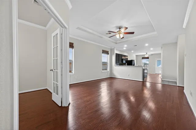 a view of an empty room with wooden floor and a window