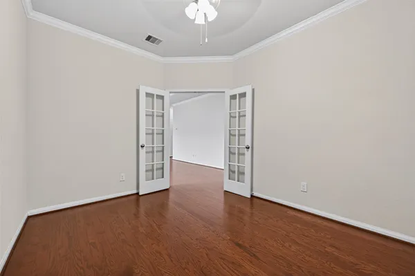 a view of an empty room with wooden floor