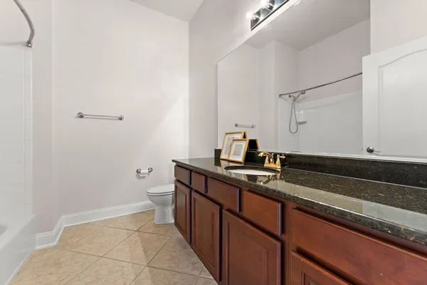 a bathroom with a granite countertop toilet and a shower