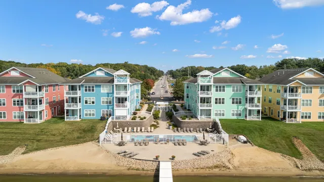 a kitchen with granite countertop stainless steel appliances a sink stove refrigerator and cabinets