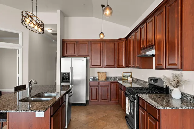 a kitchen with stainless steel appliances granite countertop a stove a sink dishwasher and a refrigerator