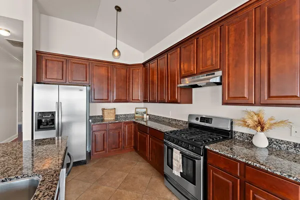 a kitchen with a dining table chairs and refrigerator