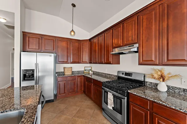 a kitchen with a dining table chairs and refrigerator