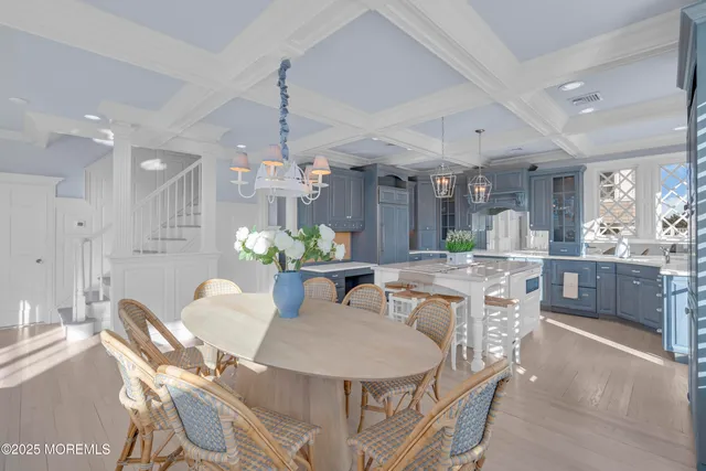 a dining room with furniture a chandelier and kitchen view