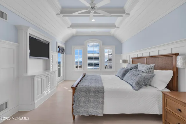 a bedroom with a balcony a bed and a flat screen tv