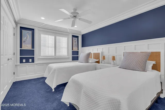 a spacious bedroom with two beds and a ceiling fan