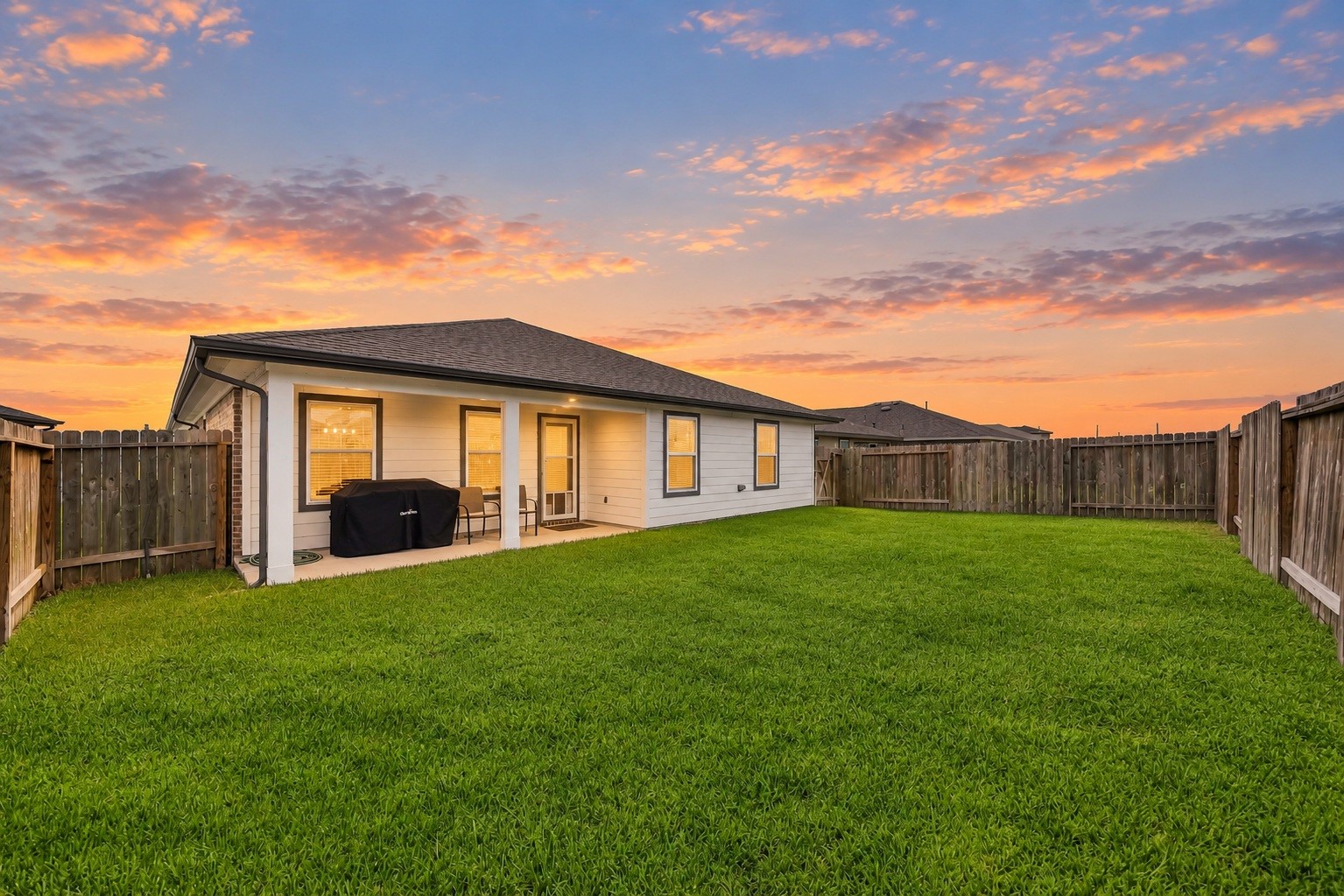 919 Tall Shire Court Rosharon, TX 77583 - Photo 18 of 19 Highlighting impressive lot depth, this private backyard space includes a covered patio overhang and a sprawling grassy area. Full perimeter wooden fencing ensures complete privacy.