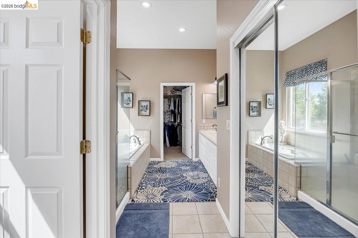 158 Rock Ridge Lane Copperopolis, CA 95228 - Photo 34 of 72 Primary Bathroom with Dual vanities with undermount sinks and extensive counter space complement the tiled soaking tub and separate glass-enclosed shower