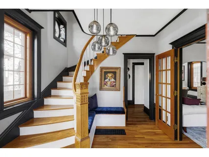 a view of entryway and hall with wooden floor