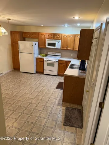 a kitchen with a refrigerator and a stove top oven