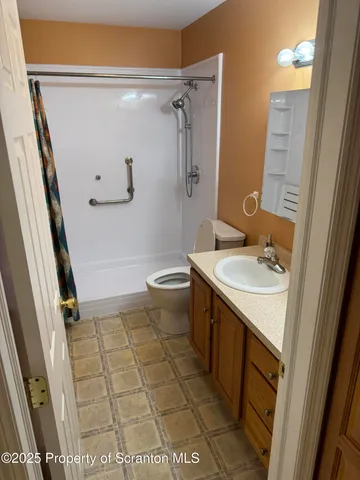 a bathroom with a granite countertop sink toilet and shower
