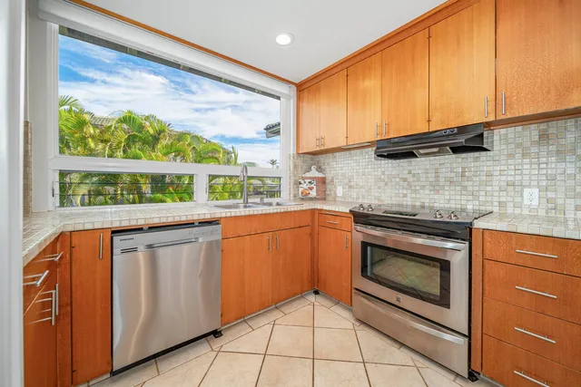 a white refrigerator freezer and a stove sitting inside of a kitchen