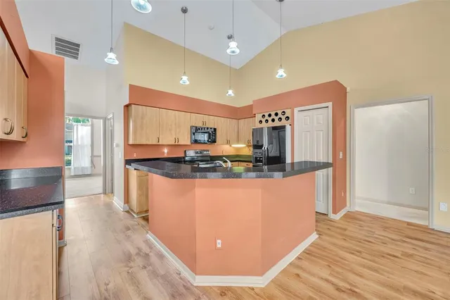 a kitchen with stainless steel appliances granite countertop a sink stove and refrigerator
