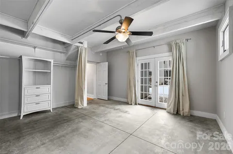 a view of an empty room with cabinet and a ceiling fan