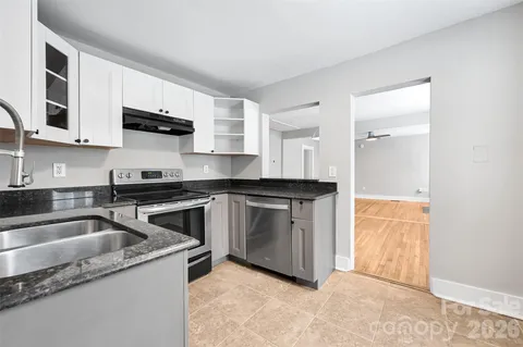 a kitchen with stainless steel appliances granite countertop a sink and a stove