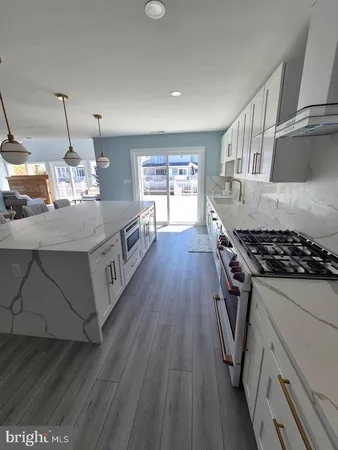 a kitchen with stove and wooden floor