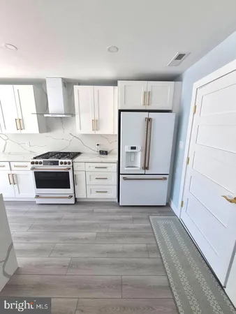 a kitchen with white cabinets and white appliances