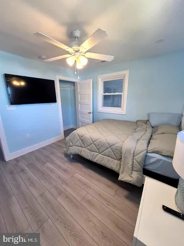 a bedroom with a bed a flat screen tv and a chandelier