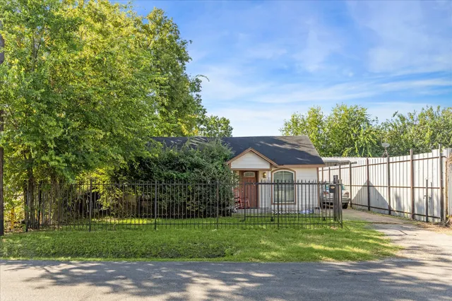 a front view of a house with a garden and trees