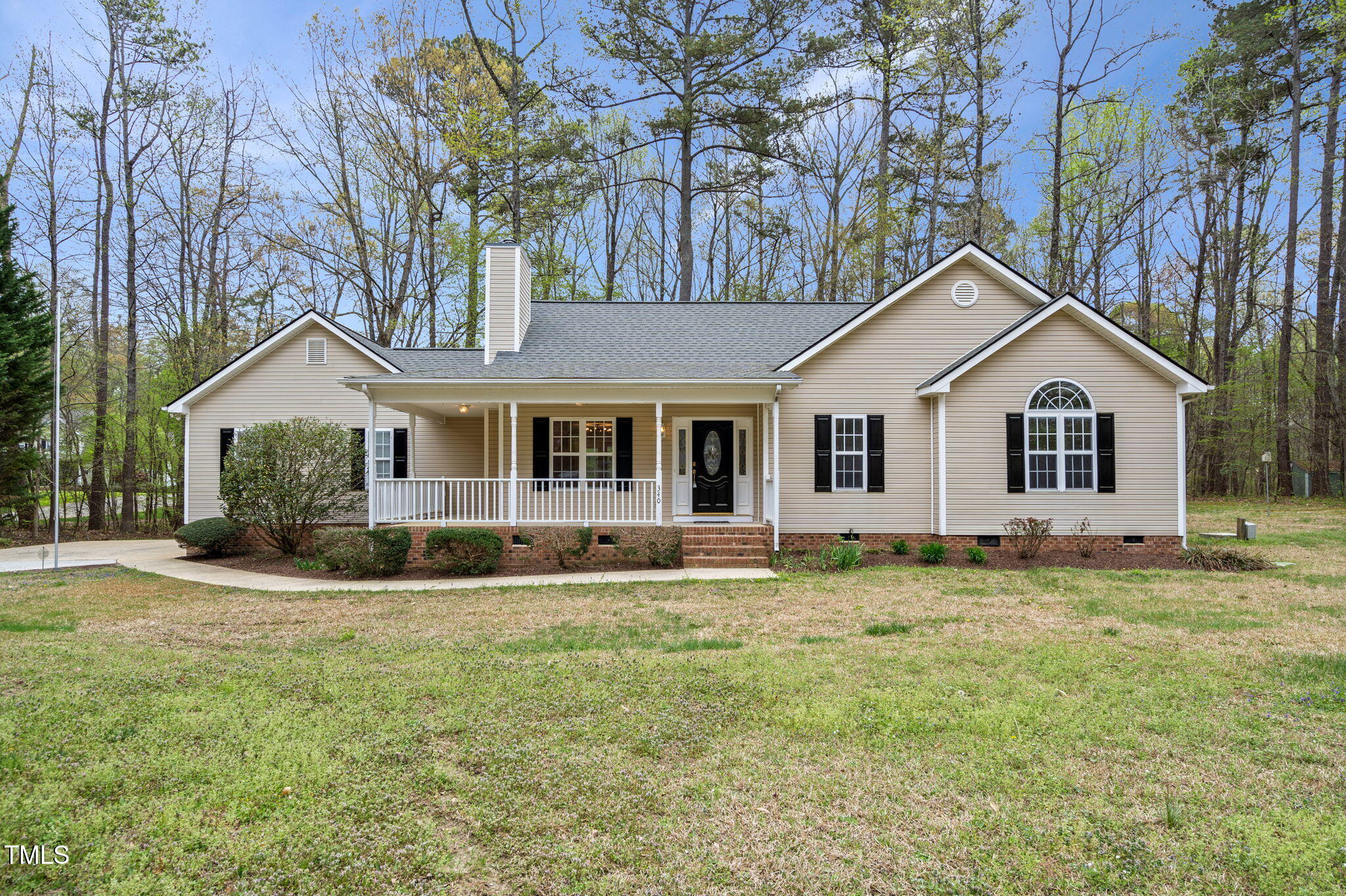 a view of a yard in front of a house with large tree