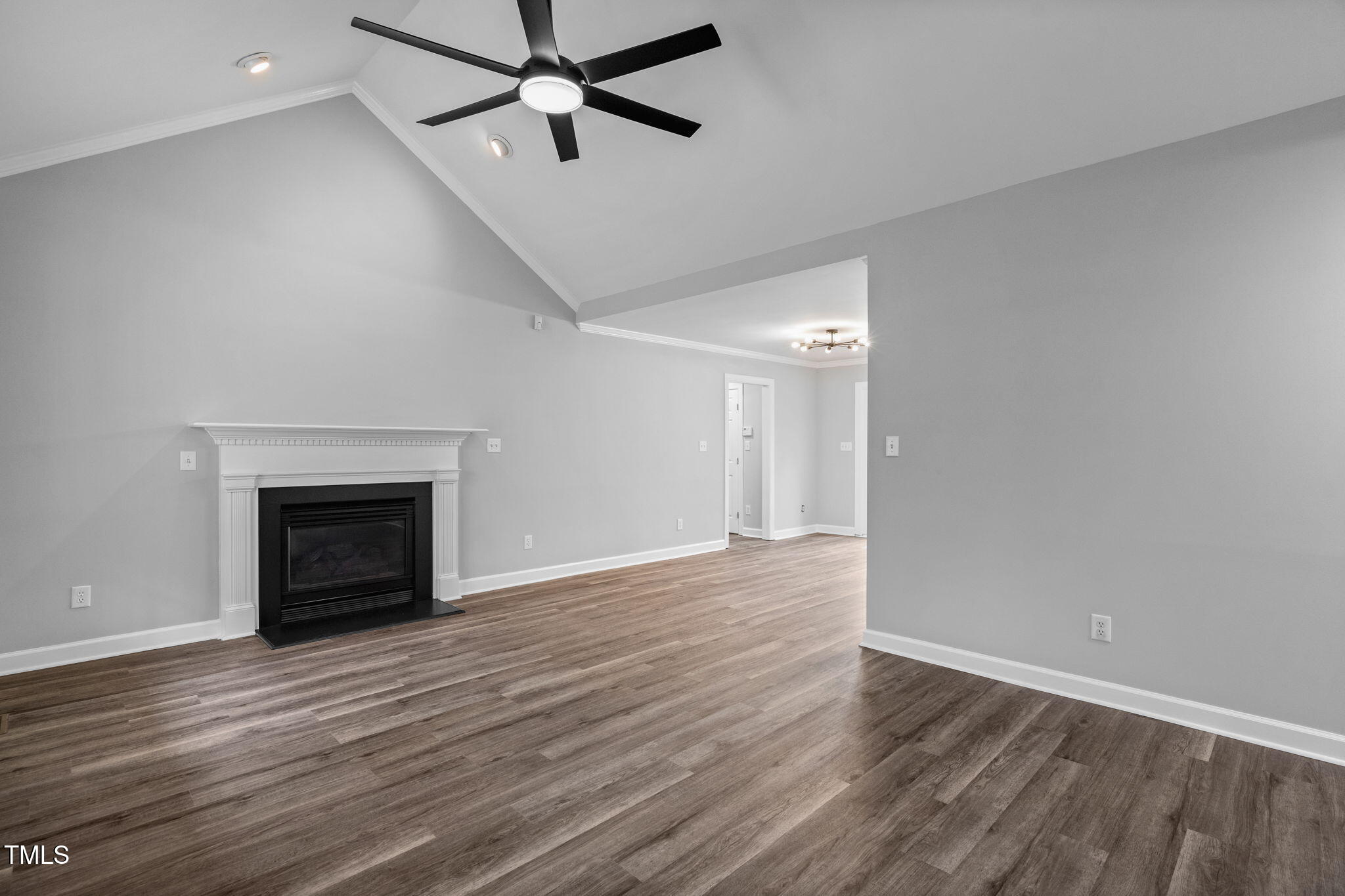 340 Castleberry Road Clayton, NC 27527 - Photo 6 of 31 a view of an empty room with wooden floor fireplace and a window